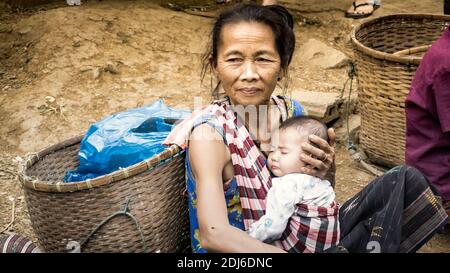 Laos - décembre 2015 : une femme du Laos dans un bazar local avec son bébé Banque D'Images