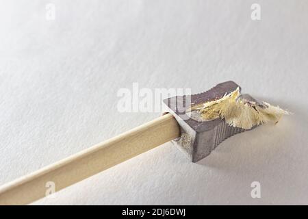 Crayon cassé avec taille-crayon métallique, tige de plomb cassée et copeaux sur fond de papier blanc Banque D'Images