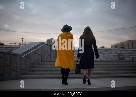 Les filles marchent dans la ville. Les femmes en vêtements chauds descendent dans la rue le soir. Filles de l'arrière. La vie dans une ville de fans. Banque D'Images