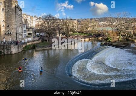 Trois canoistes sur la rivière Avon, le long de l'eau qui fait rage dans Pulteney Weir, à Bath, Somerset, Royaume-Uni, le 8 décembre 2020 Banque D'Images