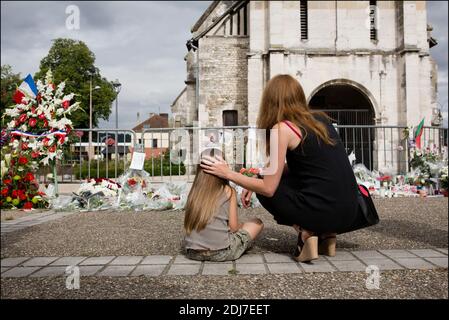 Devant l'église dans laquelle le prêtre a été tué lors d'une cérémonie d'hommage le 28 juillet 2016 à Saint-Etienne-du-Rouvray, en France, au prêtre français Jacques Hamel qui a été tué il y a deux jours dans l'église lors d'une prise d'otages revendiquée par le groupe de l'État islamique. Les enquêteurs français ont formellement identifié le second jihadiste qui a attaqué une église et tué un prêtre, un jeune homme connu des autorités après avoir essayé de se rendre en Syrie, a déclaré une source dans le bureau du procureur le 28 juillet. Ils l'ont nommé Abdel Malik Petitjean, 19 ans, qui a été tué par la police lors de l'attaque le long de wi Banque D'Images