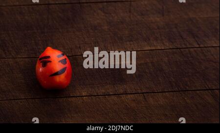 Un couple de tomates aux visages drôles. Le concept d'une alimentation et d'un mode de vie sains. Isolé sur un fond en bois. Banque D'Images