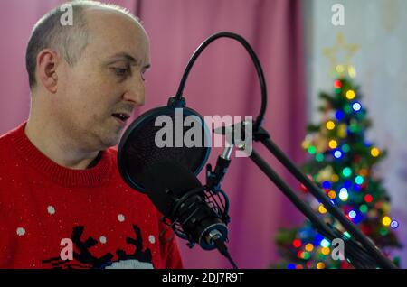 Un homme chantant dans un microphone pour enregistrer des voix. Banque D'Images