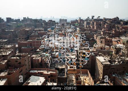 PAS DE WEB/PAS D'APPS - l'artiste franco-tunisien "Calligragraffiti" El Seed et son équipe ont passé trois semaines à travailler sur le projet perception pour créer une étonnante murale sur 50 bâtiments dans le quartier Manshiyat Naser, connu sous le nom de "ville des ordures", situé au pied des collines Mokattam, dans le centre du Caire, Égypte le 8 août 2016. Photo d'Etienne Bouy/ABACAPRESS.COM Banque D'Images