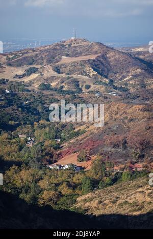 Des lignes rouges de phos trichent le long de la colline au-dessus du canyon de Modjeska tombèrent par des avions qui combattent le « feu de Bond » dans le comté d'Orange, en Californie, aux États-Unis Banque D'Images