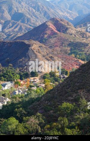 Des lignes rouges de phos trichent le long de la colline au-dessus du canyon de Modjeska tombèrent par des avions qui combattent le « feu de Bond » dans le comté d'Orange, en Californie, aux États-Unis Banque D'Images