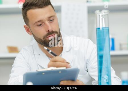 Jeune homme effectuant une expérience scientifique Banque D'Images