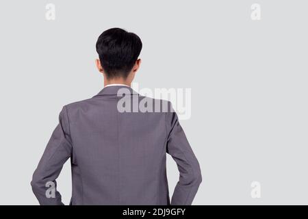 Vue arrière du jeune homme d'affaires asiatique en costume main dans la poche avec confiance isolé sur fond blanc, l'arrière de l'homme d'affaires est directeur ou exécutif Banque D'Images