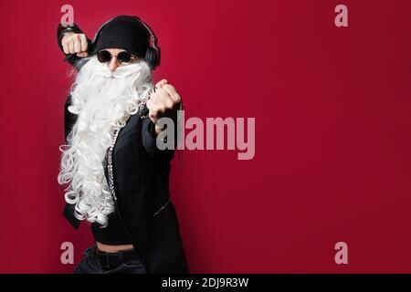 DJ Père Noël avec lunettes de soleil et casque à l'écoute de la musique de Noël en train de s'amuser. Rock Party Time. Mariez Noël. Banque D'Images