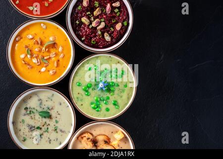 Soupe à la crème végétalienne, prise de vue avec espace de copie. Une variété de soupes en purée sur fond noir Banque D'Images