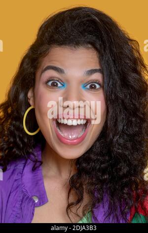 Portrait d'une jeune fille mignonne aux cheveux foncés faisant des visages Banque D'Images