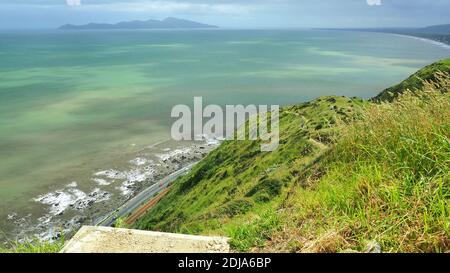 En regardant vers le nord sur la piste d'escarpement de Paekakariki, en Nouvelle-Zélande, la plate-forme est un pas avant une descente abrupte Banque D'Images