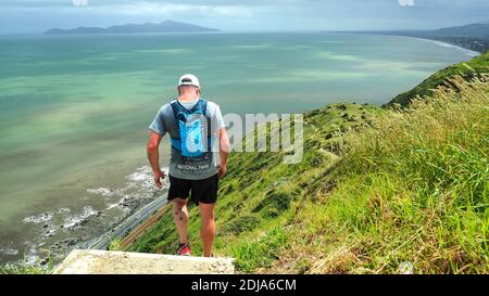 Un coureur commence l'une des descentes abruptes sur le Paekakariki Escarpment Track, sur la côte de Kapiti en Nouvelle-Zélande Banque D'Images