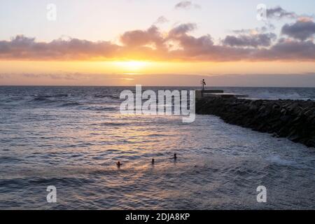 Hastings, East Sussex, Royaume-Uni. 14 décembre 2020. Hardy nageurs dans la mer au lever du soleil, un jour de brise mais très doux, avec la température prévue pour atteindre 13C. Carolyn Clarke/Alamy Live News Banque D'Images