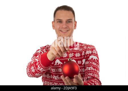 Jeune homme gai portant le style d'hiver tricots porte un Globe rouge de Noël sur fond isolé Banque D'Images