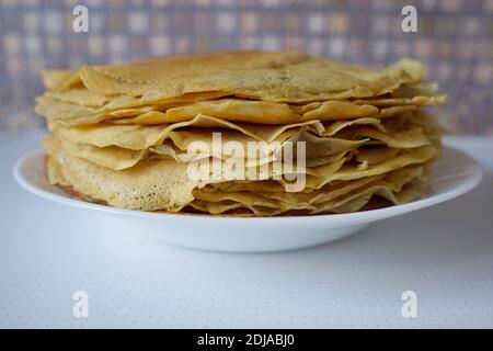 Fines crêpes croustillantes sur une assiette blanche. Cuisine traditionnelle russe pendant le Shrovetide ou tout petit déjeuner. Banque D'Images