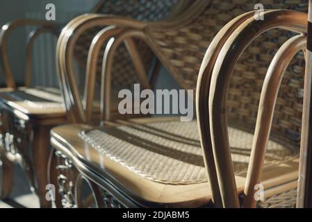 Partie des chaises en osier pour se détendre en gros plan, deux chaises se tiennent à l'ombre et le soleil se reflète sur la surface laquée. Banque D'Images