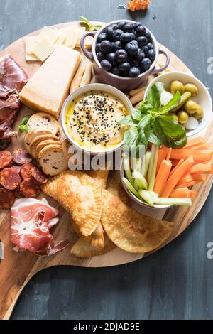 Cuisine espagnole savoureuse sur une planche de bois avec sa poignée sur la partie gauche en bas de la scène. Banque D'Images