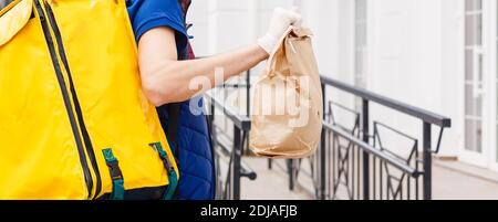 Portrait of a smiling man standing livraison avec sac à dos thermo jaune pour la livraison de nourriture dans la rue en plein air Banque D'Images