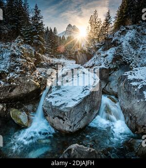 Soleil d'hiver brillant à travers la forêt et un wetterhorn sur Rychenbach ruisseau dans la vallée de Rosenlaui Banque D'Images