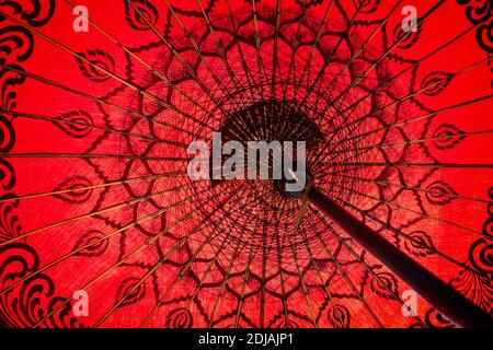 Gros plan sur un parapluie birman traditionnel rouge, vue de l'intérieur, sur fond asiatique Banque D'Images