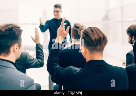 vue arrière. les employés posent des questions lors d'un briefing d'affaires Banque D'Images