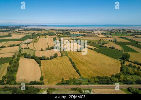 Vue aérienne sur la campagne, les polders, la baie de Cancale et le village de Saint-Benoit-des-ondes. Voies ferrées au premier plan Banque D'Images