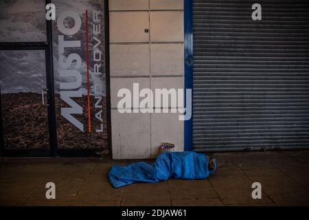 Le sommeil agace se trouve dans un sac de couchage sur la chaussée froide le long du Victoria Embankment pendant une journée d'hiver dans la capitale Londres, Angleterre, Royaume-Uni Banque D'Images