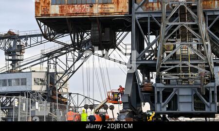 14 décembre 2020, Saxe-Anhalt, Gräfenhainichen: Les travailleurs de l'assemblage travaillent sur un bras oscillant pendulaire d'un épandeur sur le terrain du Musée industriel de Ferropolis et du lieu de l'événement. La réhabilitation de l'épandeuse, qui pèse plus de 1000 tonnes, fait environ 102 mètres de long et 36 mètres de haut et est en cours depuis novembre. Les travaux devraient être terminés au printemps 2021. Pour la première fois, le toit de la grande machine d'exploitation minière à ciel ouvert sera accessible aux fauteuils roulants comme plate-forme de visiteur. Photo: Hendrik Schmidt/dpa-Zentralbild/dpa Banque D'Images