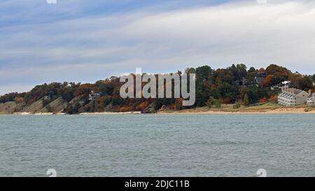 Rive du lac Michigan avec chalets et arbres dans le feuillage d'automne par une journée venteuse avec de grandes vagues Banque D'Images