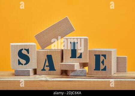 blocs en bois avec la vente de mots, isolé contre fond jaune Banque D'Images