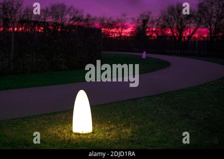 Veilleuse dans le parc. Allée dans le parc public avec ciel de coucher de soleil. Lanterne lumineuse dans le jardin nocturne. Chemin vide. Ambiance. Banque D'Images