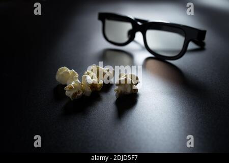 Fzlakes de pop-corn gros plan sur le noir avec des lunettes 3D sur fond. Banque D'Images
