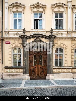 Maison de ville de Prague. Une porte en bois ornée et une entrée raffinée à une maison de ville typique dans le quartier de la vieille ville, dans le centre de Prague, en République tchèque. Banque D'Images