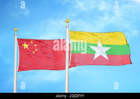 La Chine et le Myanmar deux drapeaux sur les mâts et le bleu nuageux ciel Banque D'Images