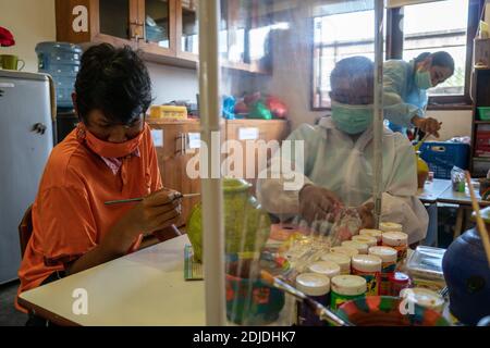 BALI/INDONÉSIE-OCT 23 2020: Les enfants handicapés apprennent à colorer. Ils sont accompagnés d'un thérapeute. Ils utilisent des masques et des hamzat Banque D'Images