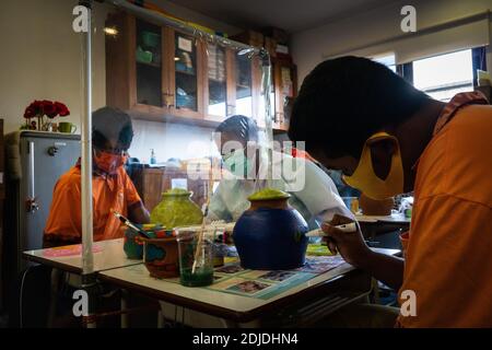 BALI/INDONÉSIE-OCT 23 2020: Les enfants handicapés apprennent à colorer. Ils sont accompagnés d'un thérapeute. Ils utilisent des masques et des hamzat Banque D'Images