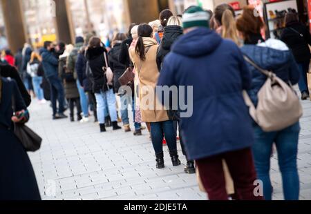 Munich, Allemagne. 14 décembre 2020. Les clients font la queue devant un magasin dans la zone piétonne. A partir de 16.12.2020, la vie publique sera considérablement réduite dans toute l'Allemagne. En plus de la plupart des magasins, les garderies, les écoles et les centres de soins post-scolaires resteront fermés, au moins jusqu'au 10 janvier. Credit: Sven Hoppe/dpa/Alay Live News Banque D'Images