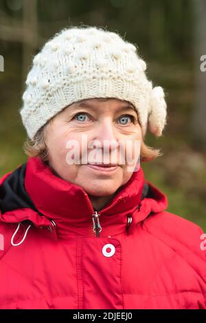 Portait de femme d'âge moyen regardant l'appareil photo en hiver chiffons Banque D'Images