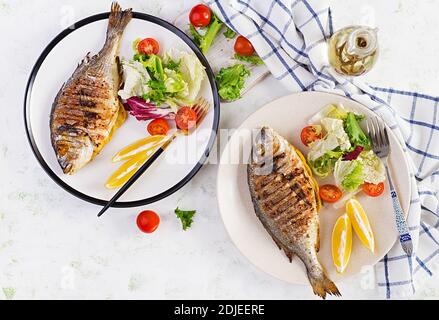 Délicieux dorado grillé ou poisson de mer avec salade, épices, dorada grillé sur une assiette. Vue de dessus, au-dessus de la tête, espace de copie Banque D'Images