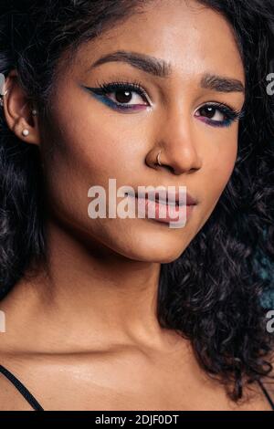 Photo de la femme portant un maquillage frais regardant l'appareil photo en studio. Banque D'Images