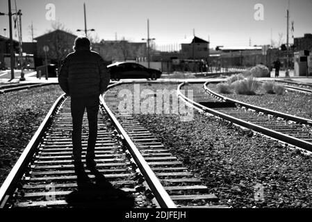 Un homme solitaire marche le long des voies ferrées qui traversent Santa Fe, au Nouveau-Mexique. Banque D'Images