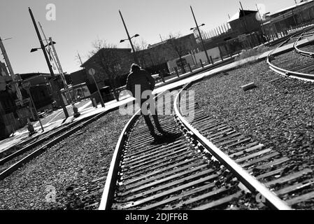 Un homme solitaire marche le long des voies ferrées qui traversent Santa Fe, au Nouveau-Mexique. Banque D'Images