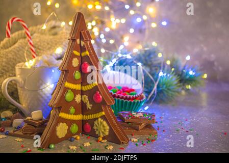 Maison créative chocolat fait à la main en forme d'arbre de Noël avec des décorations, le fond de Noël du nouvel an avec effet de lumières de bokeh Banque D'Images