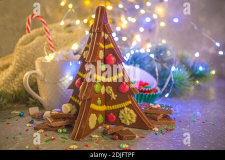 Maison créative chocolat fait à la main en forme d'arbre de Noël avec des décorations, le fond de Noël du nouvel an avec effet de lumières de bokeh Banque D'Images