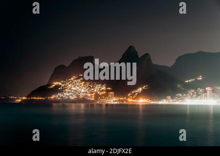 Vue de nuit sur les montagnes, le bidonville de Vidigal et la plage de Leblon avec lumières, à Rio de Janeiro, Brésil Banque D'Images