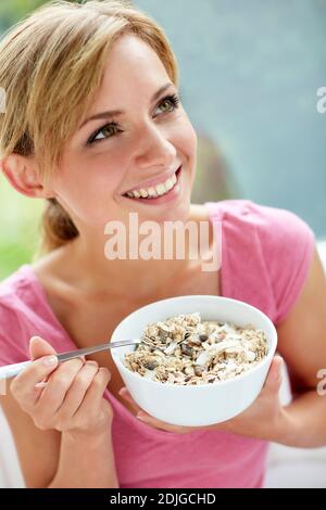 Belle femme mangeant un bol de céréales Banque D'Images