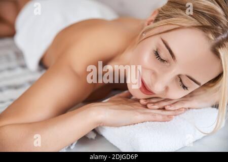 Femme élégante avec un sourire mignon se détendre tout en passant du temps dans hammam Banque D'Images