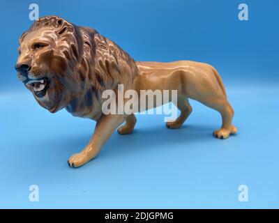 Figurine de lion en porcelaine d'époque sur fond bleu Banque D'Images