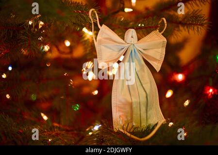 Deux masques chirurgicaux se sont formés dans la forme astucieuse d'un ange avec des ailes, placé sur l'arbre de Noël, espoir pendant la pandémie de covid-19 souffrances aux États-Unis. Banque D'Images